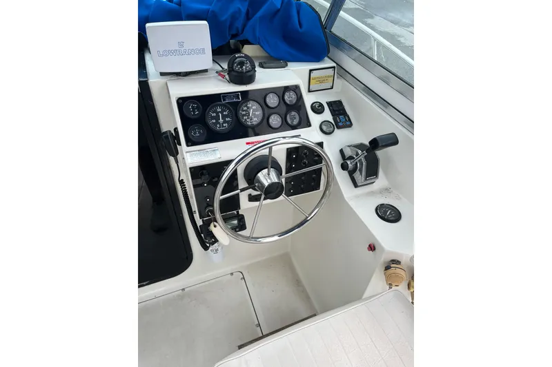 Slide: The Image of 1995 Celebrity 2500 Fish Hawk boat dashboard with steering wheel and control panel. - 22
