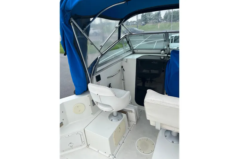 Slide: The Image of 1995 Celebrity 2500 Fish Hawk boat interior with blue canopy and white seating. - 6