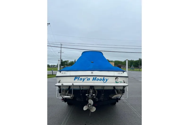 Slide: The Image of 1995 Celebrity 2500 Fish Hawk boat with blue cover, named "Play'n Hooky." - 7