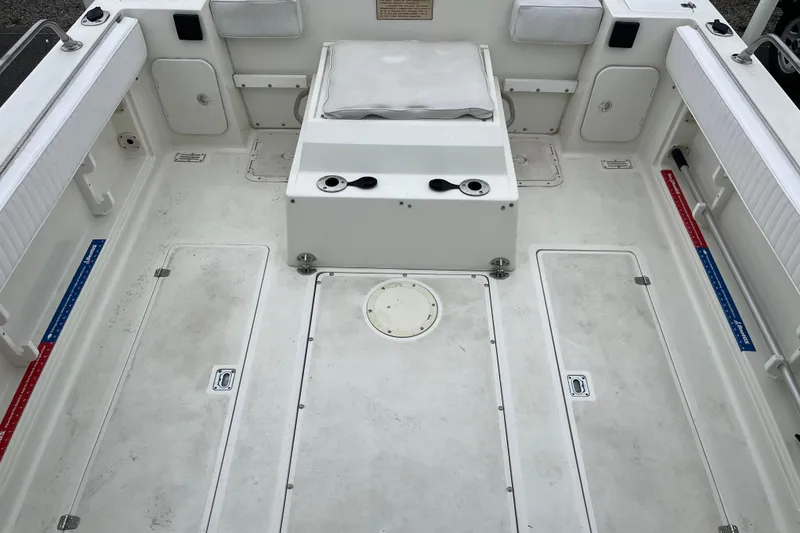 Slide: The Image of 1995 Celebrity 2500 Fish Hawk boat interior with white seating and storage compartments. - 8