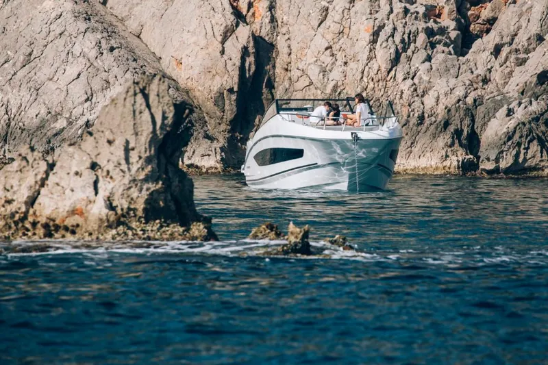 Slide: The Image of 2024 Beneteau Flyer 10 boat cruising near rocky cliffs. - 14