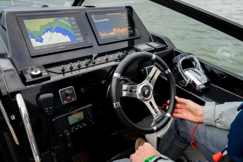 Slide: The Image of 2024 Beneteau Flyer 10 cockpit with advanced navigation system and steering wheel. - 23