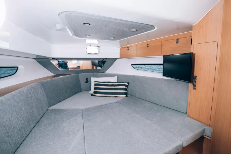 Slide: The Image of 2024 Beneteau Flyer 10 cabin interior with grey seating and wall-mounted TV. - 33