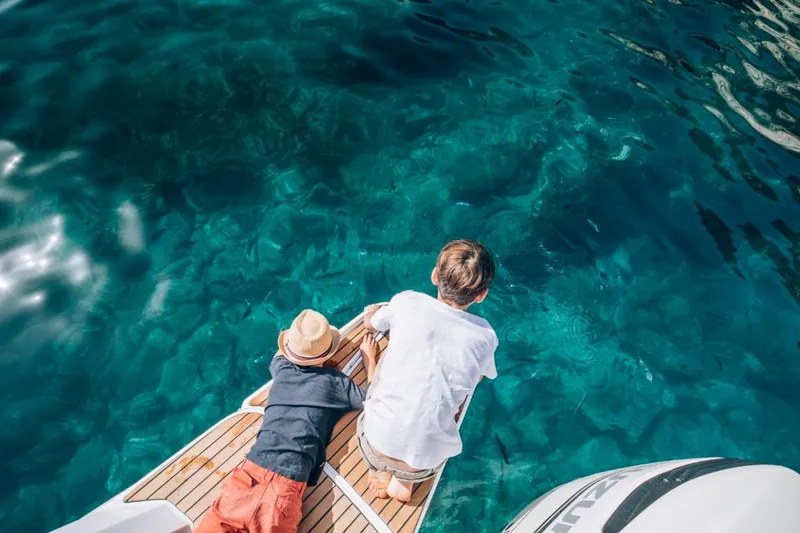 Slide: The Image of Two people relaxing on a 2024 Beneteau Flyer 10 boat, enjoying clear blue water. - 52