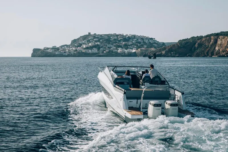 Slide: The Image of 2024 Beneteau Flyer 10 cruising near a coastal town. - 6