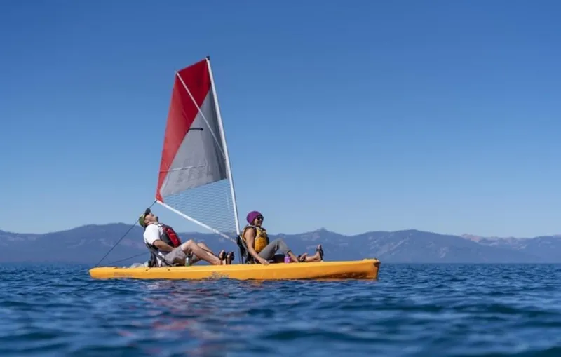 Slide: The Image of Two people sailing on a 2023 Hobie Compass Duo kayak on a lake. - 9