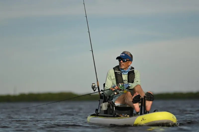 Slide: The Image of Man fishing on a 2023 Hobie iTrek 9 Ultralight kayak in calm waters. - 7