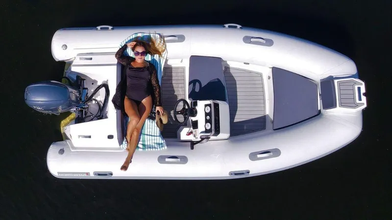 Slide: The Image of 2022 Northstar Axis 3.8 boat with a person sunbathing on deck, aerial view. - 1