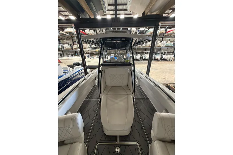 Slide: The Image of 2022 Fountain 34 Center Console boat interior with seating and helm in storage facility. - 14