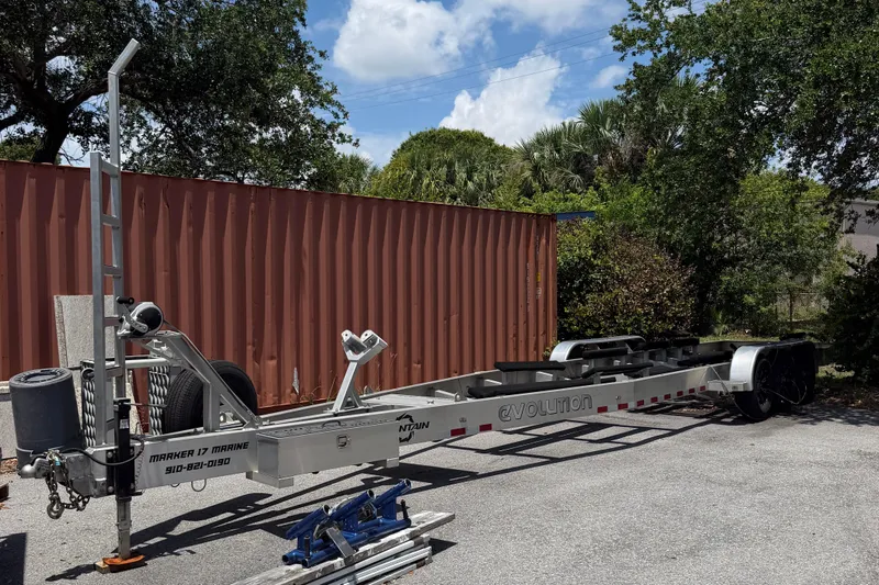 Slide: The Image of Boat trailer for 2022 Fountain 34 Center Console, parked outdoors near shipping container. - 23