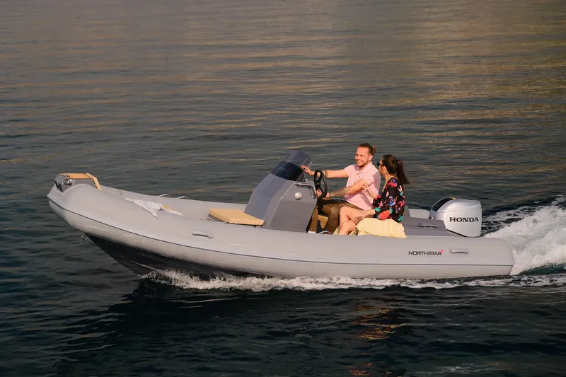 Slide: The Image of 2024 Northstar Axis 4.8 boat cruising on water with two passengers enjoying the ride. - 6