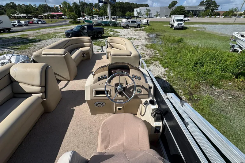 Slide: The Image of 2011 Bennington 2274GLi pontoon boat interior with beige seating and steering console. - 6