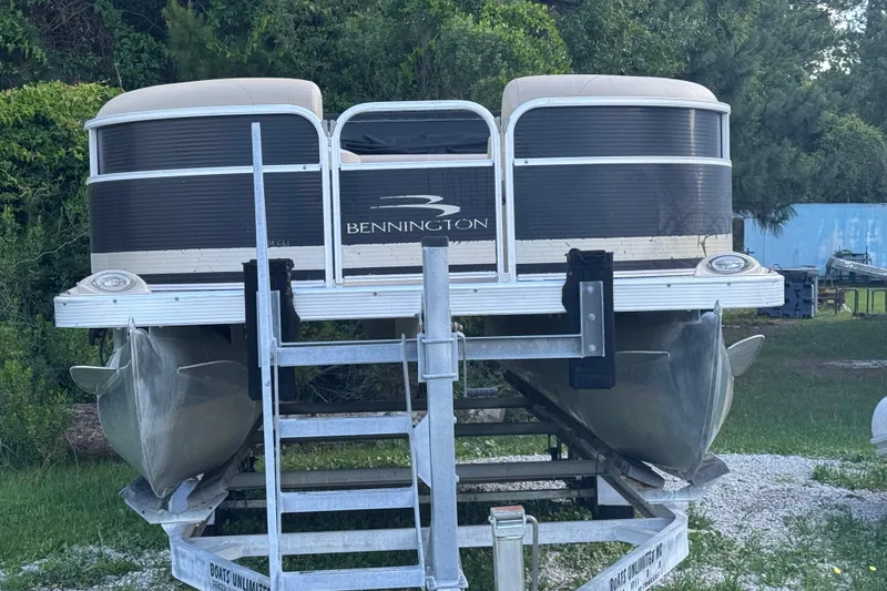 Slide: The Image of 2011 Bennington 2274GLi pontoon boat on trailer, surrounded by greenery. - 9