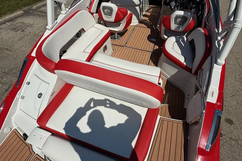 Slide: The Image of 2025 Crownline Eclipse E235 boat interior with red and white seating, wood flooring. - 11