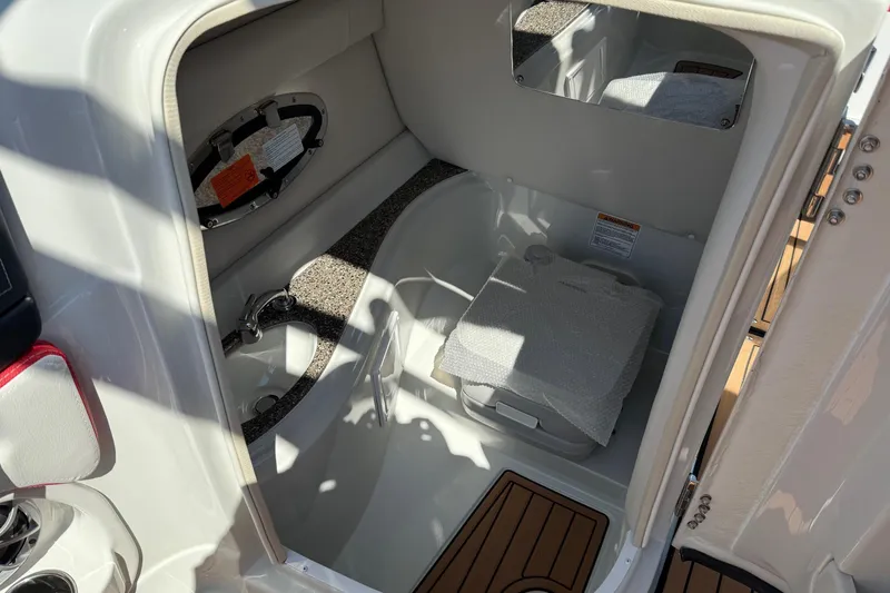 Slide: The Image of Interior of 2025 Crownline Eclipse E235 boat, featuring compact bathroom amenities. - 13