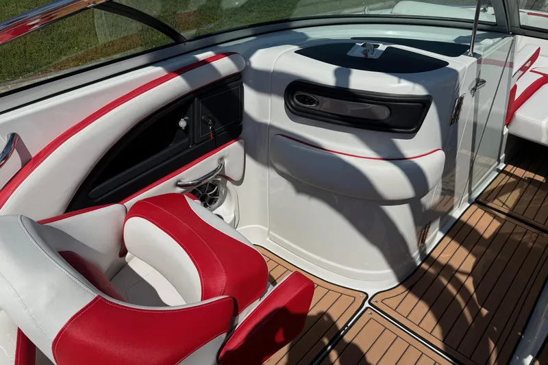 Slide: The Image of Interior of 2025 Crownline Eclipse E235 boat with red and white seating and wood flooring. - 7