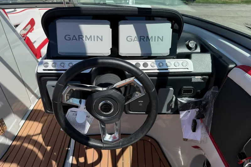 Slide: The Image of 2025 Crownline Eclipse E235 boat dashboard with Garmin displays and steering wheel. - 9
