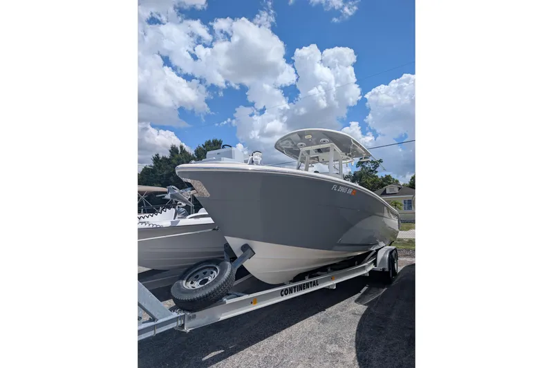 The Image of 2020 Cobia 262 Center Console boat on trailer under blue sky. - 1