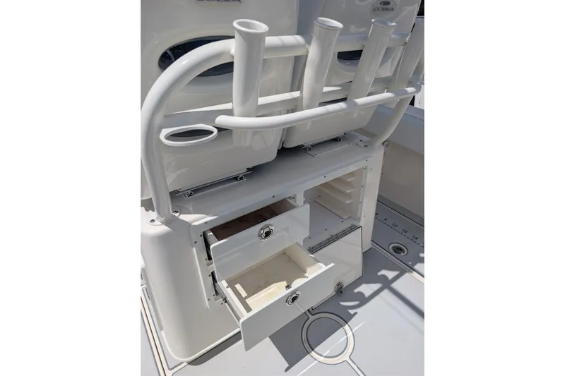 Slide: The Image of 2020 Cobia 262 Center Console boat with open storage compartments and rod holders. - 15