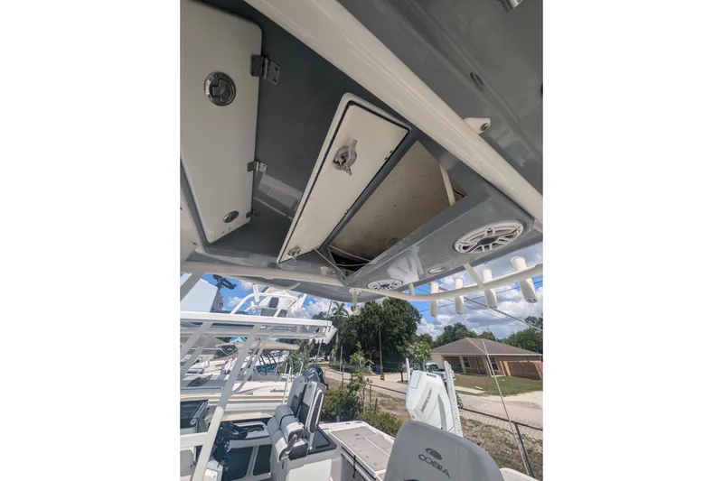 Slide: The Image of 2020 Cobia 262 Center Console boat interior with open storage compartment and speakers. - 16