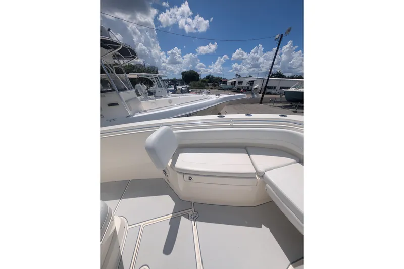 Slide: The Image of 2020 Cobia 262 Center Console boat with white seating under a sunny sky. - 18