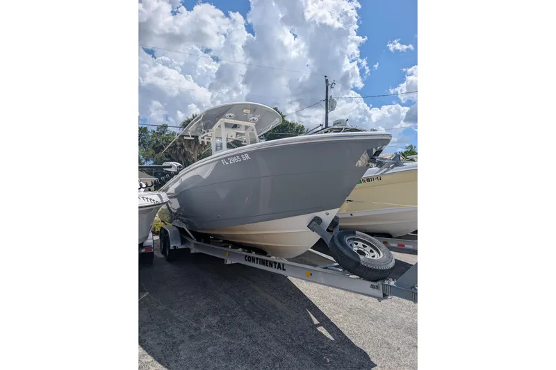 Slide: The Image of 2020 Cobia 262 Center Console boat on trailer under a cloudy sky. - 20