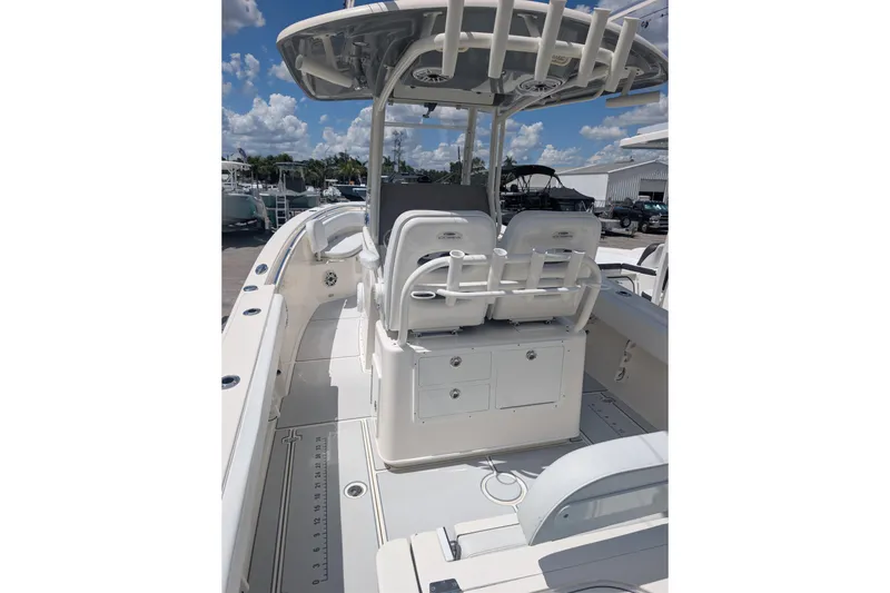 Slide: The Image of 2020 Cobia 262 Center Console boat with seating and storage, under a clear blue sky. - 3