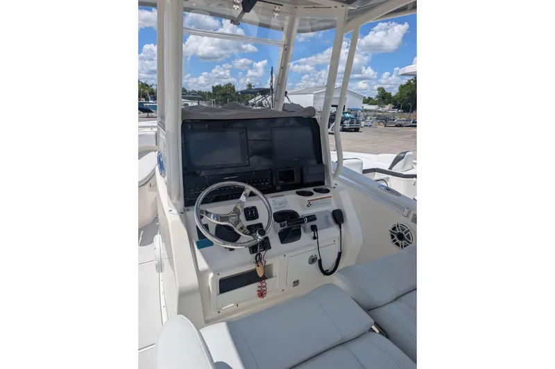 Slide: The Image of 2020 Cobia 262 Center Console boat dashboard with steering wheel and navigation screens. - 6