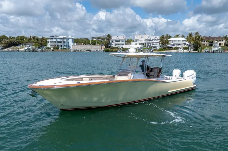 The Image of 2020 Mag Bay 33 CC boat cruising on a scenic waterfront with houses in the background. - 0