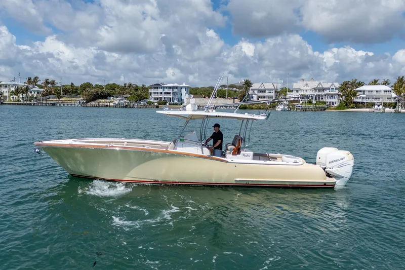 Slide: The Image of 2020 Mag Bay 33 CC boat cruising on a scenic waterway under a cloudy sky. - 12