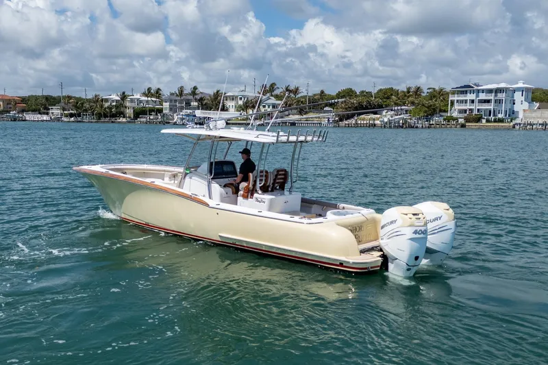 Slide: The Image of 2020 Mag Bay 33 CC boat cruising on a sunny day with twin Mercury engines. - 13