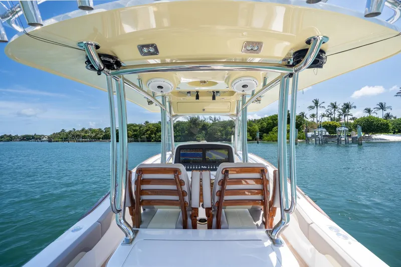 Slide: The Image of 2020 Mag Bay 33 CC boat on serene water with lush greenery backdrop. - 27