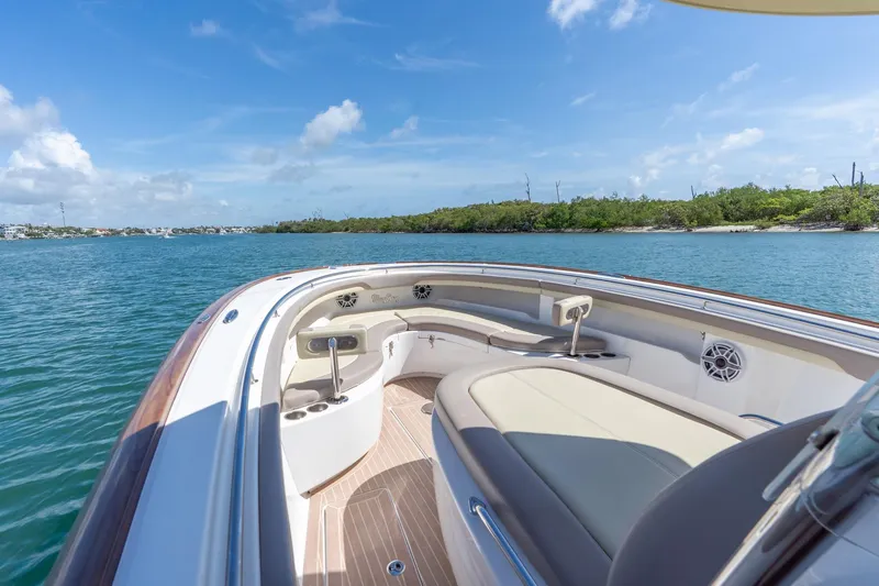 Slide: The Image of 2020 Mag Bay 33 CC boat interior with seating, on calm water under blue sky. - 29