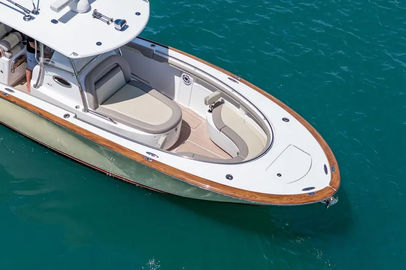 Slide: The Image of 2020 Mag Bay 33 CC boat on clear blue water, featuring sleek design and wood accents. - 3
