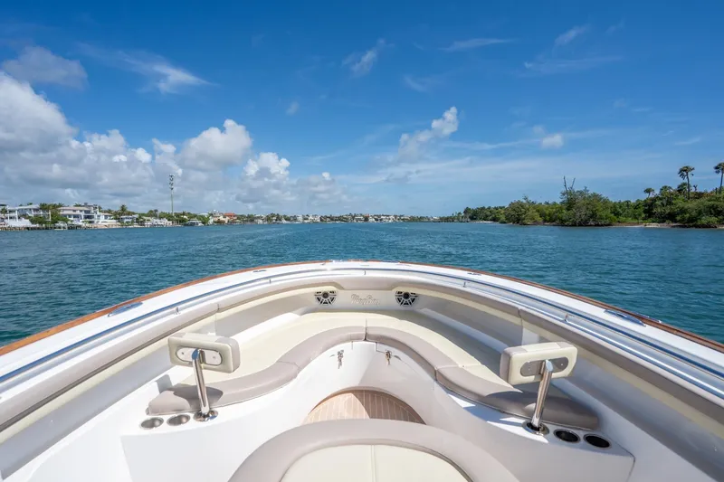Slide: The Image of 2020 Mag Bay 33 CC boat cruising on a sunny day with scenic coastal view. - 31