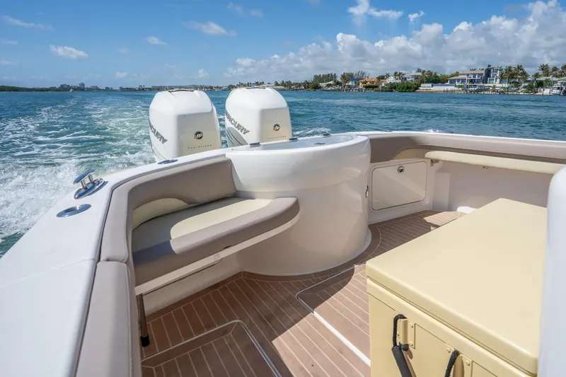 Slide: The Image of 2020 Mag Bay 33 CC boat interior with twin Mercury engines on a sunny day. - 34