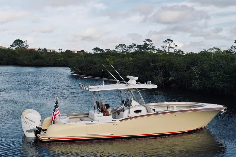 Slide: The Image of 2020 Mag Bay 33 CC boat cruising on a serene river with lush greenery. - 6