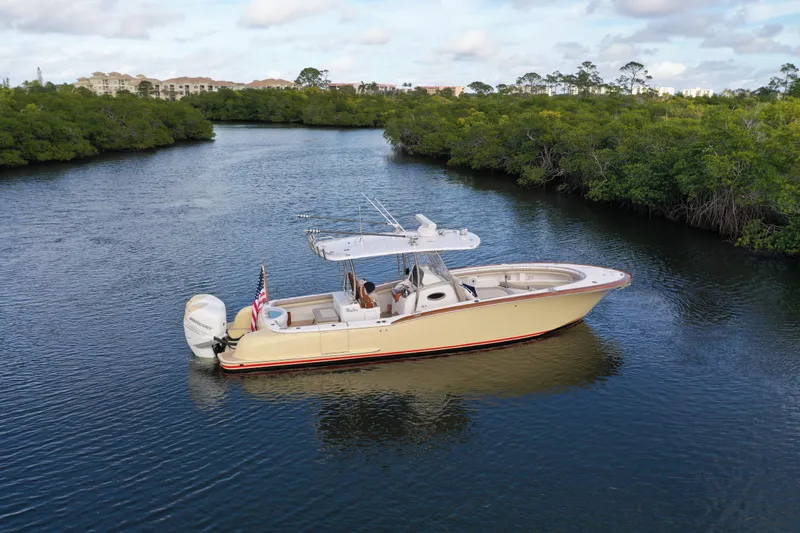 Slide: The Image of 2020 Mag Bay 33 CC boat cruising on a serene river with lush greenery. - 7