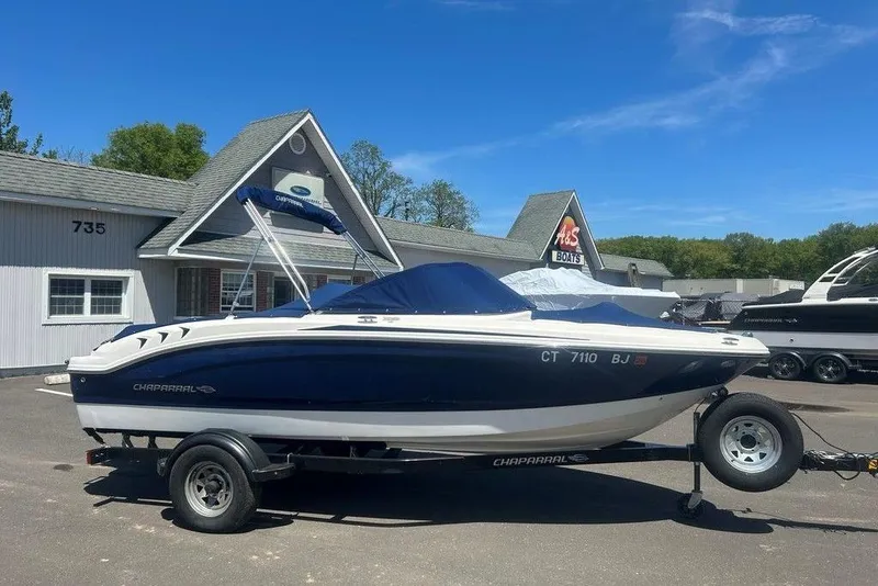Slide: The Image of 2017 Chaparral 19 H2O Sport boat on trailer, parked outside dealership. - 8