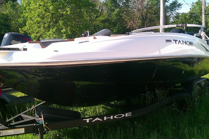 The Image of 2026 Tahoe 2150 CC boat on trailer, parked on grass with trees in background. - 0