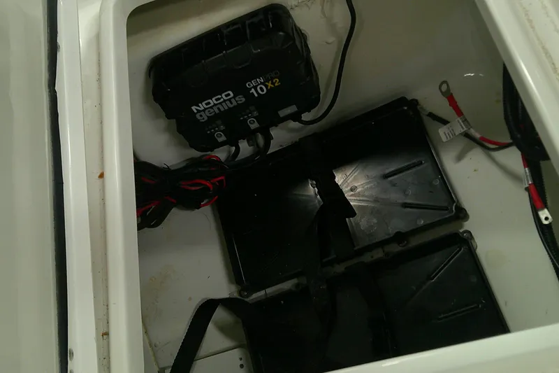 Slide: The Image of Battery compartment of 2026 Tahoe 2150 CC with NOCO Genius charger and wiring. - 11