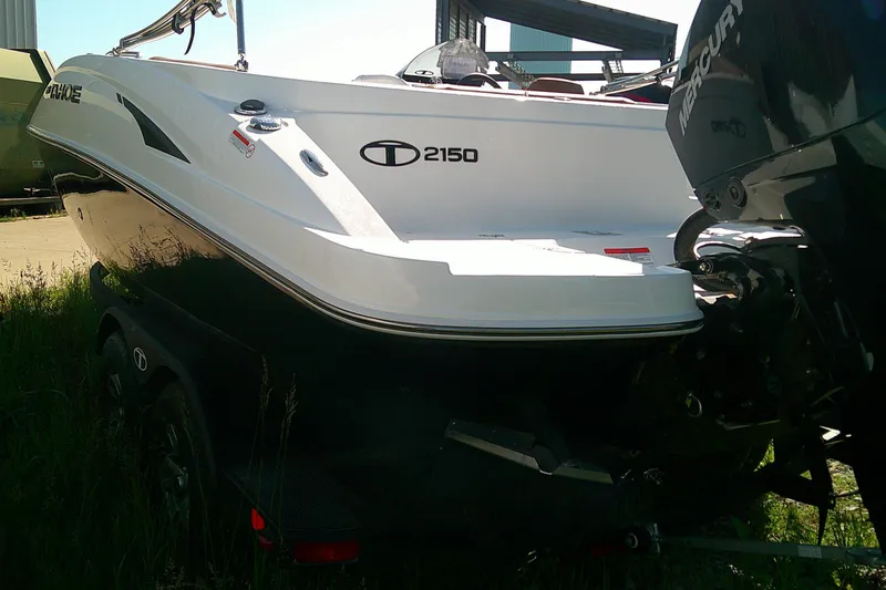 Slide: The Image of 2026 Tahoe 2150 CC boat with Mercury engine, parked on a trailer in sunlight. - 6