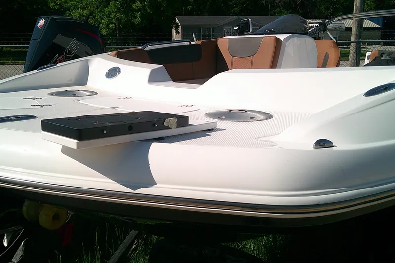 Slide: The Image of 2026 Tahoe 2150 CC boat deck with seating and motor, in a sunny outdoor setting. - 8