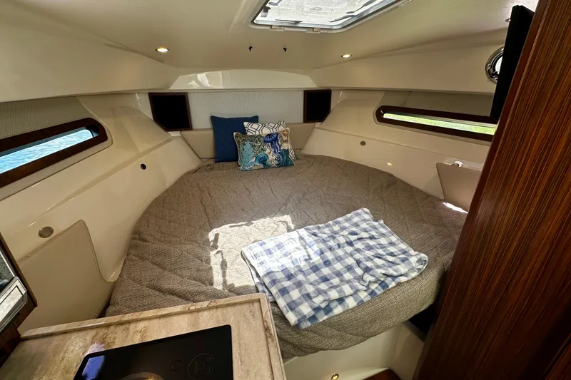 Slide: The Image of Cozy cabin interior of 2019 Pursuit OS 325 Offshore boat with bed and pillows. - 14