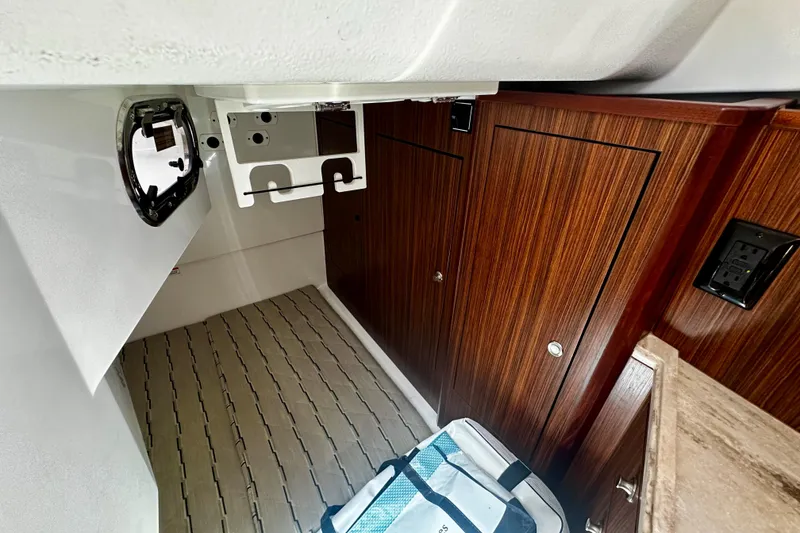 Slide: The Image of 2019 Pursuit OS 325 Offshore cabin interior with wood paneling and storage compartments. - 18
