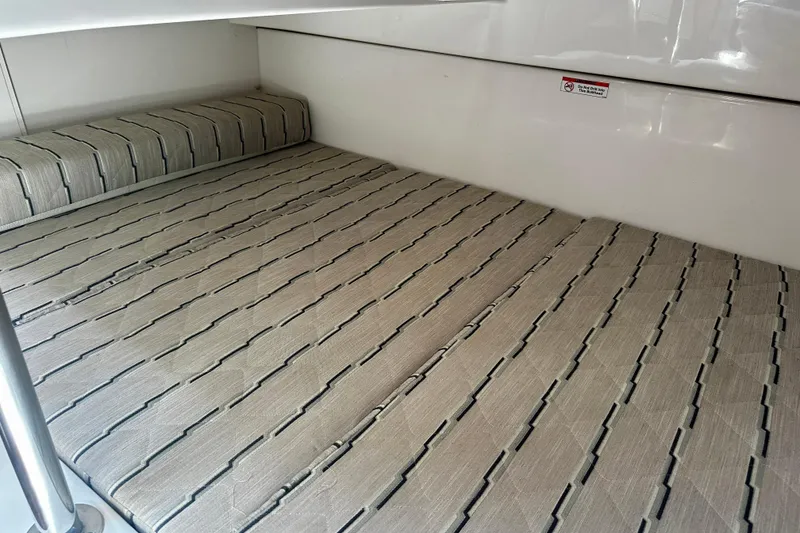 Slide: The Image of 2019 Pursuit OS 325 Offshore cabin interior with striped bedding and sleek design. - 20