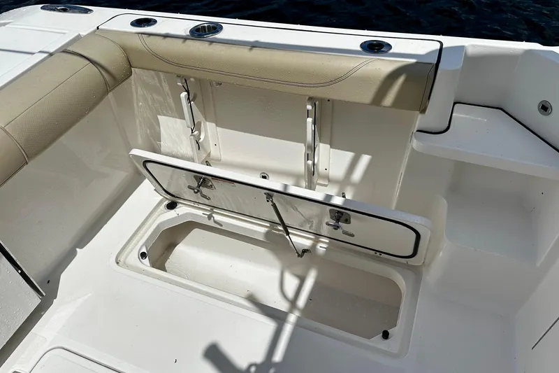Slide: The Image of 2019 Pursuit OS 325 Offshore boat interior with open storage compartment and cushioned seating. - 27