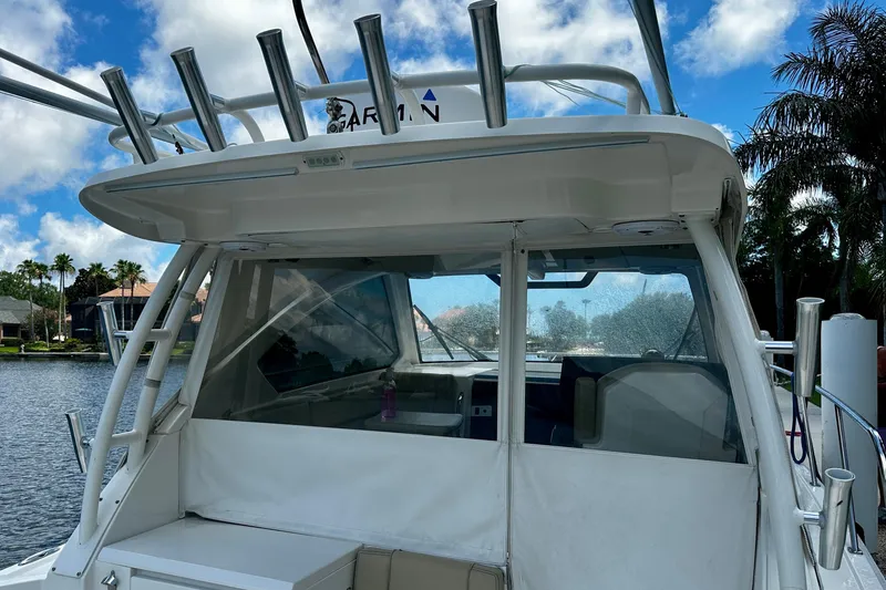 Slide: The Image of 2019 Pursuit OS 325 Offshore boat docked by a scenic waterfront with palm trees. - 29