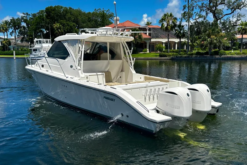 Slide: The Image of 2019 Pursuit OS 325 Offshore boat with twin Yamaha engines on a scenic waterway. - 4