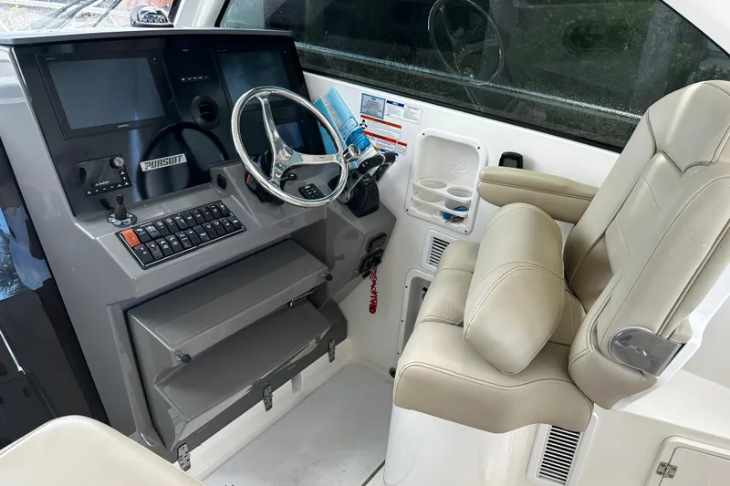 Slide: The Image of 2019 Pursuit OS 325 Offshore helm with dual screens and comfortable captain's chair. - 8